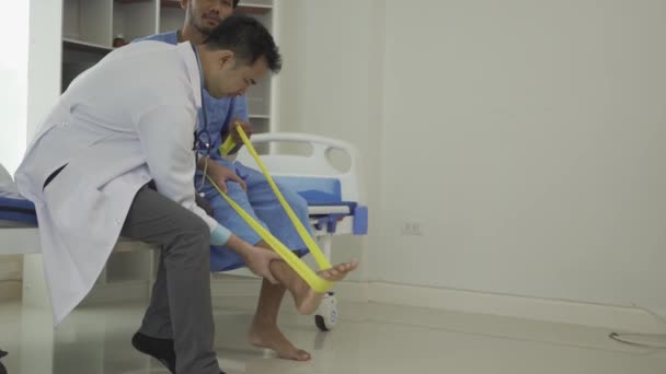 Мужчина Делает Упражнения Эластичной Лентой Программа Физиотерапии Врач Концепции Здравоохранения — стоковое видео