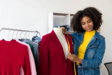 Afrikalı Amerikalı kız internetten canlı yayın yoluyla giysi sunar ve satar, şık bir giyim mağazası seçer. Moda tasarımcıları yeni koleksiyonların resimlerini çiziyor.