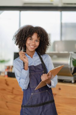 Kahve barında çalışan genç, güzel Latin Amerikalı barmen, rahat bir çatı katı tarzı kafe, yiyecek ve içecek konseptinde çalışan kasiyer..