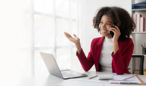Afrikalı bir kız, bir bilgisayarın aboneliği için başlatılan projenin detaylarını tartışan bir arkadaşıyla pozitif bir akıllı telefon konuşması yapıyor..