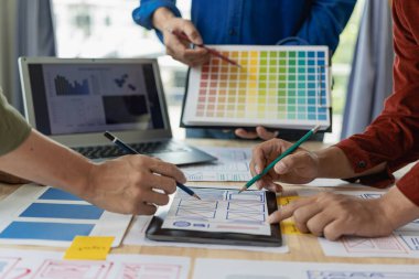 UI UX web tasarımcılarından oluşan bir ekip, UI UX UX Front Designer web sitesi geliştirme fikirlerini ön izleyerek mobil yanıt veren bir web sitesi geliştirmek için birlikte çalışıyor.