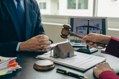 Ev müzayedesi konsepti: Yargıç elinde evin açık artırmada satışına karar vermek için tokmak tutuyor.