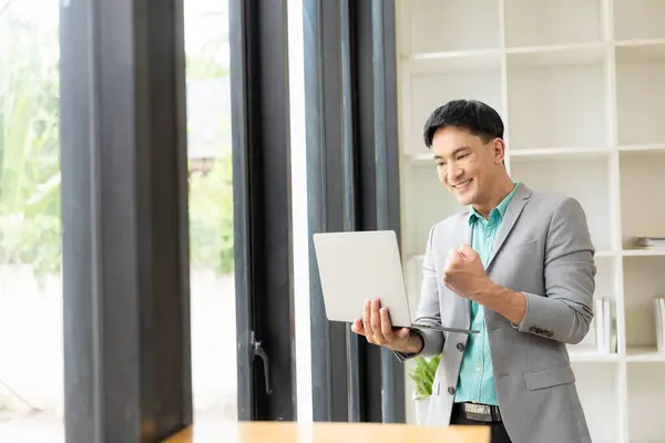 Happy Young Asian Businessman Celebrates Work Success Office Looking Laptop — Stock Photo, Image