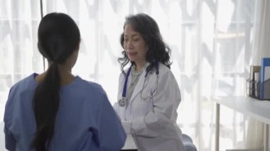Kıdemli bir kadın doktor, hastane gözlem odasında bulunan tıp öğrencilerine çeşitli hastalıklarla ilgili tavsiyelerde bulunuyor..