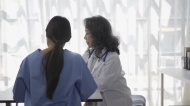 Kıdemli bir kadın doktor, hastane gözlem odasında bulunan tıp öğrencilerine çeşitli hastalıklarla ilgili tavsiyelerde bulunuyor..