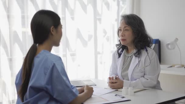 高齢の女性医師が 患者のさまざまな病気に関する病院観察室の医学生にアドバイスをしています — ストック動画