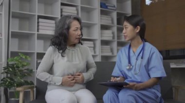 Bir hemşire, yaşlı bir insana evinin oturma odasında hastalığıyla ilgili tavsiye verir. Evde yaşlı hasta bakımı sağlanması