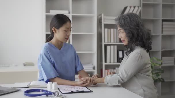 看護師は 自宅のリビングルームで病気について高齢者にアドバイスします 高齢者ケアにおける医療サービスの提供 — ストック動画
