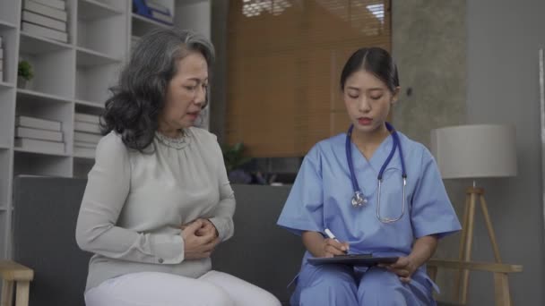 Een Verpleegkundige Geeft Advies Aan Een Bejaarde Zijn Ziekte Woonkamer — Stockvideo