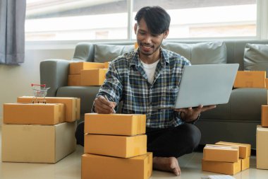 Çevrimiçi mağaza, KME iş konsepti müşterilerine siparişleri göndermeden önce ambalajda paket paketleyen Afrikalı Amerikalı erkek yönetici