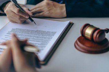İş adamı ve ekip, sözleşme imzalamadan önce sözleşmenin doğruluğu ve ortak iş yatırımına olan güveni sağlamak için avukatla sözleşme belgelerini görüştü. Yakın plan resimler.