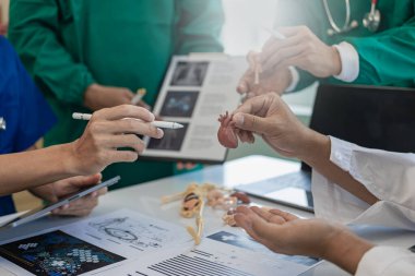 Sağlık ekipleri toplantılara dizüstü bilgisayarlarla katılır. Doktorlar ve çalışanlar belgeleri ve test sonuçlarını tartışıyor. Hastanelerdeki sağlık uzmanları yakın plan çekimde.