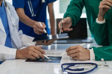 Sağlık ekipleri toplantılara dizüstü bilgisayarlarla katılır. Doktorlar ve çalışanlar belgeleri ve test sonuçlarını tartışıyor. Hastanelerdeki sağlık uzmanları yakın plan çekimde.