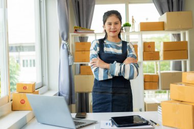 Asyalı kadın dizüstü bilgisayarlardan ve cep telefonlarından sipariş veriyor. Çevrimiçi iş ve nakliye kavramı