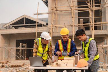 İşçiler ve mühendisler bir güneş paneli sistemi kurmaktan bahsediyorlar. Güneş paneli teknisyeni çatıya güneş panelleri kuruyor. alternatif enerji kavramları