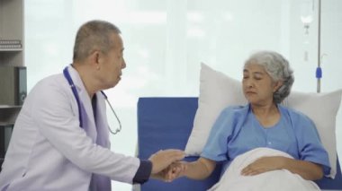 Profesyonel kıdemli erkek doktor hastanedeki yaşlı kadın hastaya danışmanlık yapıyor ve muayene ediyor. Rahatlamış atmosfer, sağlık, akıl sağlığı, yaşlılarla ilgilenme kavramı.