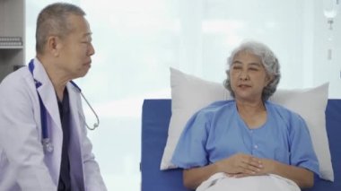 Profesyonel kıdemli erkek doktor hastanedeki yaşlı kadın hastaya danışmanlık yapıyor ve muayene ediyor. Rahatlamış atmosfer, sağlık, akıl sağlığı, yaşlılarla ilgilenme kavramı.