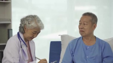 Profesyonel kıdemli erkek doktor hastanedeki yaşlı kadın hastaya danışmanlık yapıyor ve muayene ediyor. Rahatlamış atmosfer, sağlık, akıl sağlığı, yaşlılarla ilgilenme kavramı.