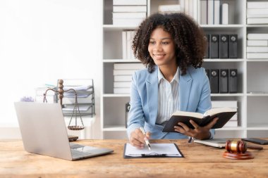 Masada otururken kontrat ve yasal belgelerle ofiste çalışan çekici genç Afrikalı Amerikalı avukat. Hukuk, hukuk, danışmanlık, adalet.
