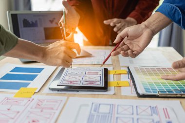 Ağ tasarımcılarından oluşan bir ekip, ux ui sisteminin görünümünü özelleştirmek için programlar ve katmanlar yazıyorlar ve birlikte hareket eden bir web sitesi geliştirmek için çalışıyorlar..