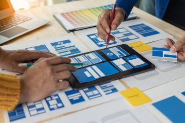 Ağ tasarımcılarından oluşan bir ekip, ux ui sisteminin görünümünü özelleştirmek için programlar ve katmanlar yazıyorlar ve birlikte hareket eden bir web sitesi geliştirmek için çalışıyorlar..