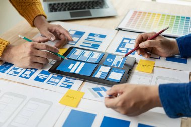 Ağ tasarımcılarından oluşan bir ekip, ux ui sisteminin görünümünü özelleştirmek için programlar ve katmanlar yazıyorlar ve birlikte hareket eden bir web sitesi geliştirmek için çalışıyorlar..