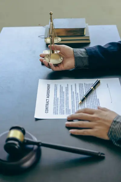 Male lawyer working with contract documents and wooden hammer on table in courtroom, justice and law, court judge, justice lawyer concept, legal advice and service vertical picture