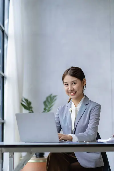金融オフィスで働く若いアジアの会計士 ラップトップで計算機を使用して販売レポートを管理 レポートを準備 バランス 税務監査 垂直画像について — ストック写真