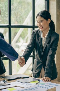 Dost canlısı Asyalı bir bayan oyuncu mülakattan sonra bir adayla tokalaşıyor. Başarılı ve kendinden emin bir iş kadını iş ortağıyla tokalaşıyor. Hoş geldiniz, tebrikler.,