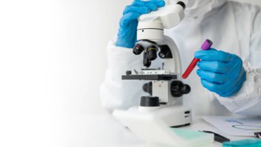 Asyalı hematolog, bir doktorun talimatlarına göre tıbbi olarak gerekli kan testlerini inceler. Kan testlerini teşhis etmeye çalışır, laboratuar yakın çekim fotoğraflarını çeker.