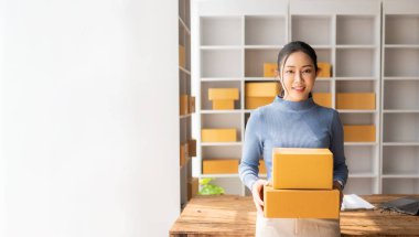 Müşteriyle akıllı telefondan konuşan Asyalı kadın, dizüstü bilgisayar, küçük işletme, e-ticaret ve çevrimiçi alışveriş, küçük ve yeni girişimci, perakende sektörü, KOBİ