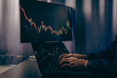 Borsa tablosuna bakan borsa simsarı, yatırım stratejisini analiz ediyor, hisse senedi grafikleri ve göstergelerle monitör ekranı ile çalışıyor, risk kararları almak için çok çalışan insanlar.