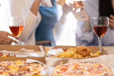 Bir grup Asyalı bayan arkadaş bir partide birlikte eğleniyorlar. Pizza partisi şarabı önemli bir anı kutluyor.