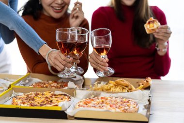 Bir grup Asyalı bayan arkadaş bir partide birlikte eğleniyorlar. Pizza partisi şarabı önemli bir anı kutluyor.