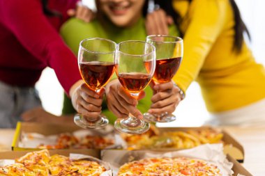 Bir grup Asyalı bayan arkadaş bir partide birlikte eğleniyorlar. Pizza partisi şarabı önemli bir anı kutluyor.