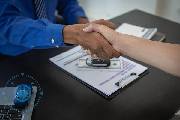 Car salesman shaking hands making deal with his customer in car business office, car sales, deal, gesture and people concept - closing dealership giving keys to new owner