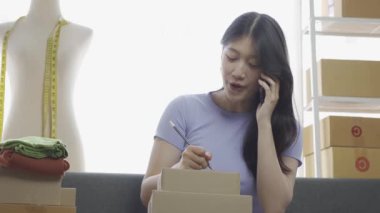 İnternette kıyafet satan Asyalı bir kız dairede dizüstü bilgisayar kullanıyor, internet günlüğü için blog kaydediyor, evdeki internet giyim mağazasında canlı yayında sevimli bir kadın var.
