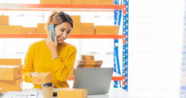 Güzel Asyalı girişimci evde KOBİ tedarik zinciri, satın alma, omnichannel satın alma veya çevrimiçi satış fikirleri ile mutlu mesut kalır.