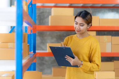 Güzel Asyalı girişimci evde KOBİ tedarik zinciri, satın alma, omnichannel satın alma veya çevrimiçi satış fikirleri ile mutlu mesut kalır.