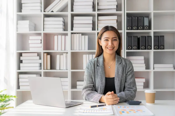 在办公室使用手提电脑进行案头计算费用的亚洲女雇员 图表数据表上的财务报告 — 图库照片