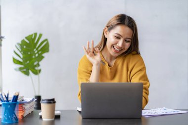 Keyifli, mutlu ve bağımsız iş yapan genç bir kadın. Ev bilgisayarını kullanan çekici bir kadın. İnternette laptop yazılımı kullanarak çalışıyor.