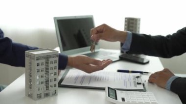Emlak şirketinin temsilcileriyle el ele tutuşun. Ev, apartman ve sabah binaları alıp satmak için. Müşteriler de ev satın almak için sözleşme yapıyor. Gayrimenkul ve kredi anlaşmaları