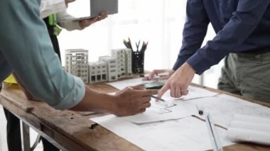 İnşaat mühendisliği ekibi mimar ve ustabaşıyla birlikte projeleri izliyor ve binanın inşaatını planlıyorlar..