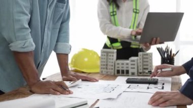 İnşaat mühendisliği ekibi mimar ve ustabaşıyla birlikte projeleri izliyor ve binanın inşaatını planlıyorlar..