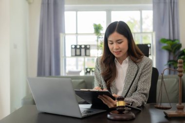 Asya ofisinde dizüstü bilgisayarlı danışman, özel bayan avukat online hukuk danışmanı sözleşmeli belgeler üzerinde çalışan eleman.