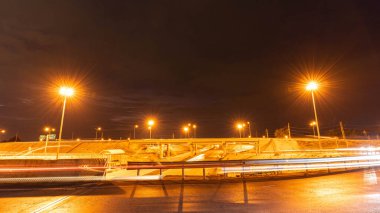 Büyük bir şehirde hızlı bir gece araba penceresinden yola doğru yol alırken araçlardan ve sokak ışıklarından gelen ışık çizgileriyle.