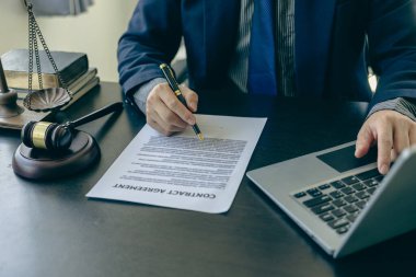 Masada çalışan ve adalet terazisine odaklanan erkek avukat, elinde kalem tutan ve hukuki tavsiyelerde bulunan avukat, çekiç yakın çekim resimli iş anlaşmazlığı servisi