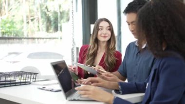 Farklı milletlerden ve iş adamlarından kadınlar, bir ajanstaki cam duvarın arkasındaki konferans salonunda konuşuyorlar. Yaratıcı yönetmenler ve proje yöneticileri iş sonuçlarını karşılaştırıyorlar.