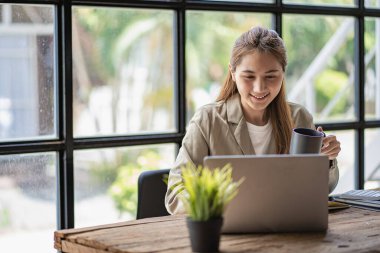 Asyalı öğrenci, genç bayan Millennial kadın teste hazırlanıyor ya da bir kafede dizüstü bilgisayarla internette sörf yapıyor, çevrimiçi bir not defterine, webinar 'a, yabancı dilleri öğreniyor.