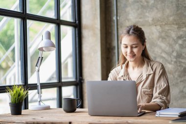 Asyalı öğrenci, genç bayan Millennial kadın teste hazırlanıyor ya da bir kafede dizüstü bilgisayarla internette sörf yapıyor, çevrimiçi bir not defterine, webinar 'a, yabancı dilleri öğreniyor.
